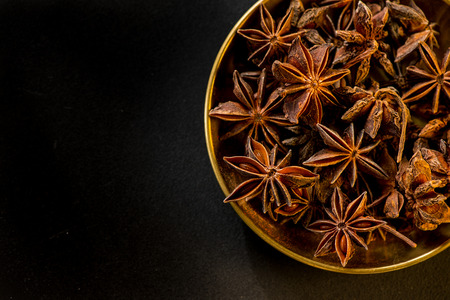 Star shape anis seeds in bowl on black slate backgroundの写真素材