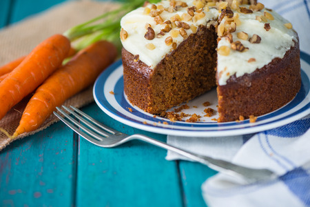 Carrot cake and cloth on table with fresh carrotsの写真素材