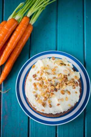 Traditional carrot cake and fresh carrots on tableの写真素材