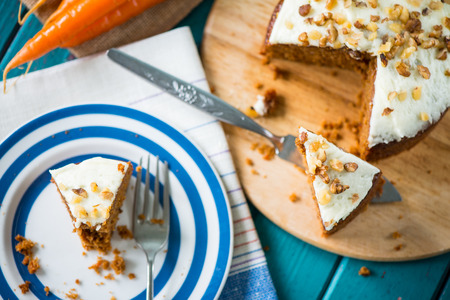 Carrot cake and cloth on table with fresh carrotsの写真素材