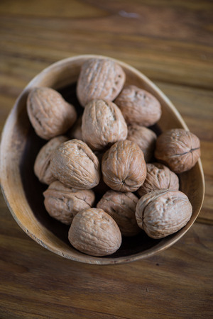 wooden bowl with walnuts on rustic tableの写真素材