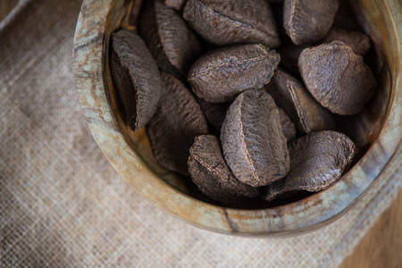 Table top view on brazilian nuts in bowl on woodの写真素材
