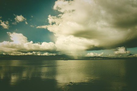 clouds over lake with vintage effectの写真素材