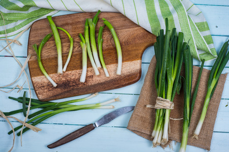 fresh green spring onion bunch on wooden tableの写真素材