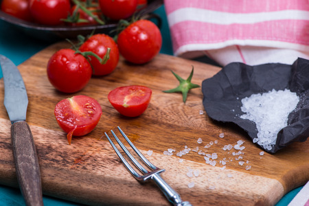cherry tomatoes on rustic board on tableの写真素材