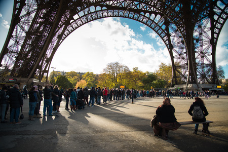 PARIS, FRANCE - NOVEMBER 11, 2014 People, mainly tourists queuing to get acces to Eiffel Tower ,...