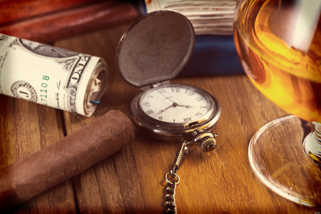 Top view, rich person or bussinesman desk with cuban cigar, bank notes and rumの写真素材