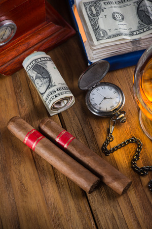 Top view, rich person or bussinesman desk with cuban cigar, bank notes and rumの写真素材