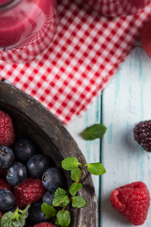 Fresh summer berries fruits in vintage bowl on rustic tableの写真素材