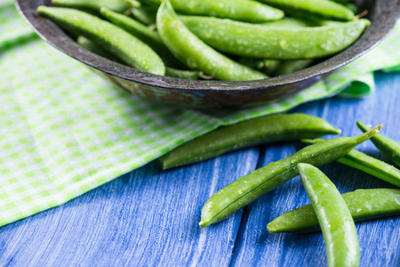 Whole fresh peas in vintage bowlの写真素材