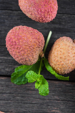Fresh ripe whole lychee fruits on wooden backgroundの写真素材