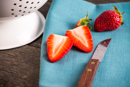 Fresh strawberry cut in half on blue clothの写真素材