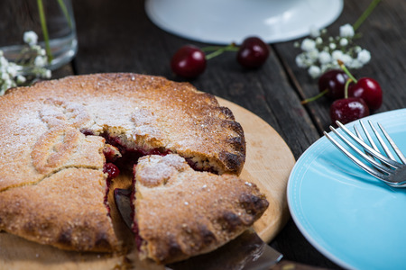Traditional homemade organic cherry pie served on wooden rustic table with fresh fruits