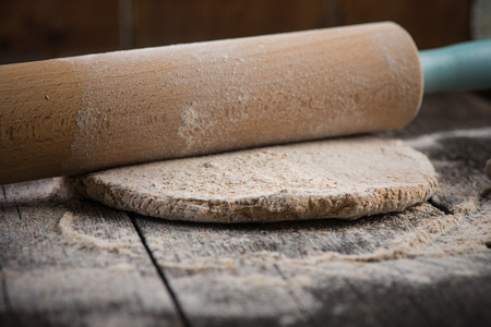 rolling wholegrain dough for homemade bread on wooden rustic tableの写真素材