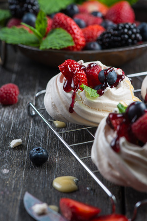 Homemade pavlova meringue with fresh berries on wooden rustic tableの写真素材