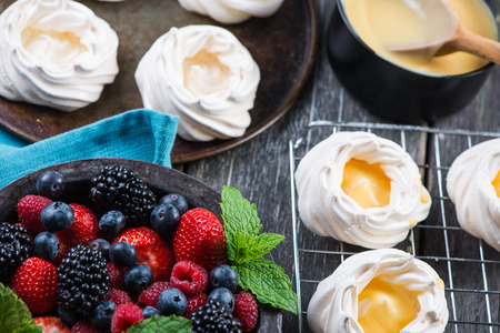 Homemade pavlova meringue with fresh berries on wooden rustic tableの写真素材