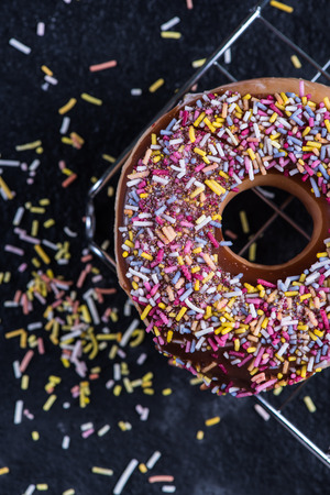 Fresh hand decorated donut and sweet colorful sprinklesの写真素材