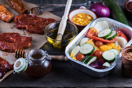 Pork in sticky glaze and fresh vegetables for home party barbecue, on wooden table