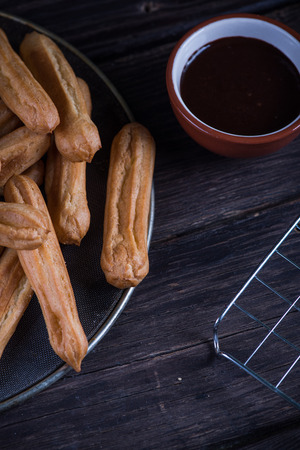 Homemade latin churros with chocolate dip on rustic tableの写真素材