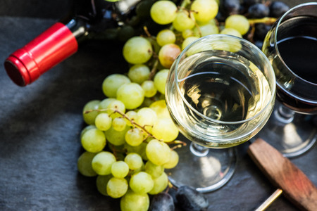 white and red wines in glasses, bottle and corkscrew overheadの写真素材