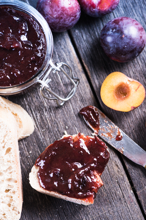 Homemade organic plum marmelade with bread on wooden boardの写真素材