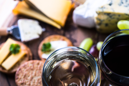 Cheese board selection with wine, on wooden rustic tableの写真素材