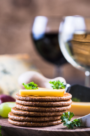 Oat crackers with cheese selection on wooden rustic boardの写真素材