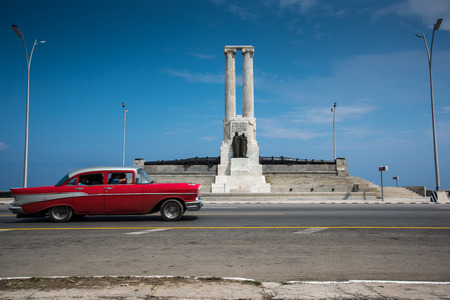 Classic american car drive past El Malecon sea front  landmark in Havana,Cubaの写真素材