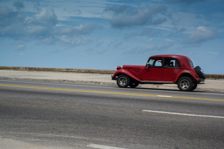 Havana, Cuba - September 28, 2015: Classic american car drive  on Malecon sea front promenade in Havana,Cuba. Classic American cars are typical landmark and tourist attraction for whole Cuban island.のeditorial素材