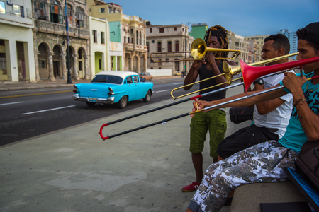 Havana, Cuba - September 25, 2015: Group of friends play music at sunset at Malecon,  most popular and famous sea front promenade in Havana, Cuba. Music is very common hobby in Cuba but also way to earn extra cash.のeditorial素材