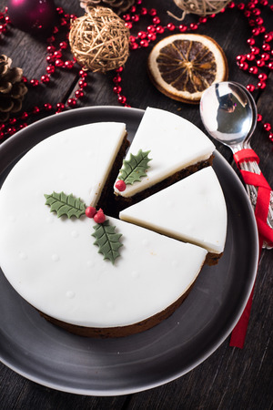 Cuting Homemade Christmas fruit cake on wooden tableの写真素材