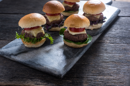 homemade mini beef burgers on serving boardの写真素材