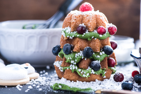 Decorating Christmas tree cake with fresh winter berry fruitsの写真素材