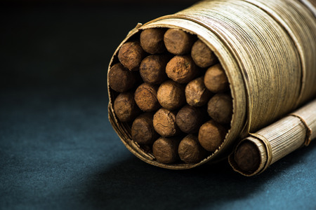 Pile of cigars in pal leafs crafted box, dark backgroundの写真素材