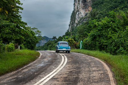 American oldtimer drive lonely on Cuban roadの写真素材