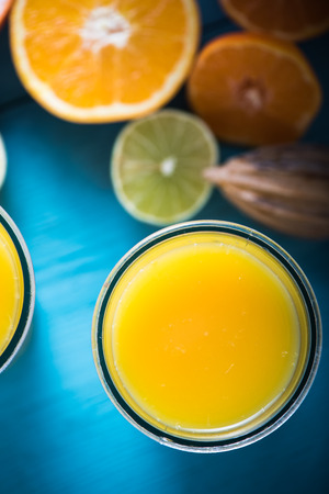 Fresh squeezed citrus juice and half cut fruitsの写真素材