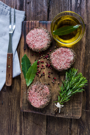 Seasonig minced meat on wooden board, view from above. Cooking concept.の写真素材
