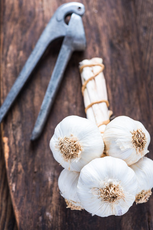 Bunch of whole garlic on wooden rustic board, still life food low light portraitの写真素材