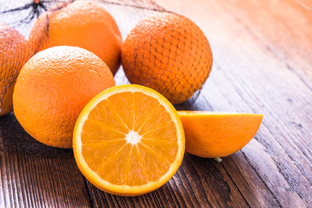 Fresh oranges in shopping net or bag, on wooden rustic table, copy text space.の写真素材