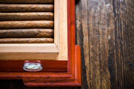 Overhead view on humidor with cigars, on wooden table. Tabacconist or cigar collector concept.の写真素材