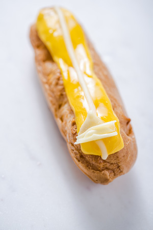 Artisan eclair sweet treat, on white marble board