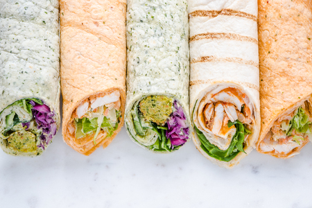 Brunch idea, healthy wrap with vegetables and toffu on white marble board.の写真素材
