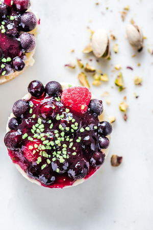 wild berry cheesecake with pistachio, on white marbleの写真素材