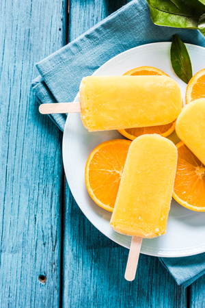 Healthy snack, orange natural ice pop on fresh fruit slicesの写真素材