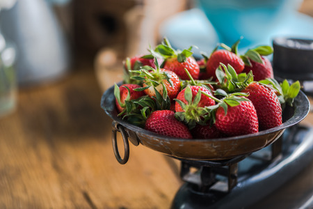 Fresh strawberries on vintage scale, in farmhouse kitchen