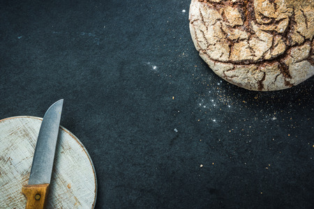 Artisan whole grain rye bread, on dark slate. Ingredients border backgroundの写真素材