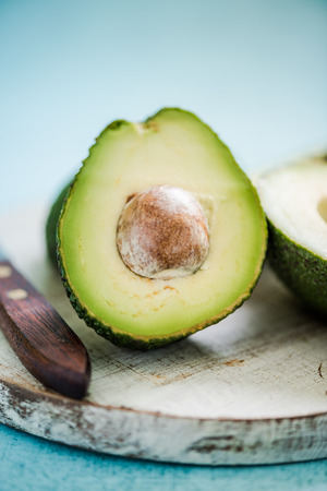 Whole and halved avocado with seed, vibrant pastel colors