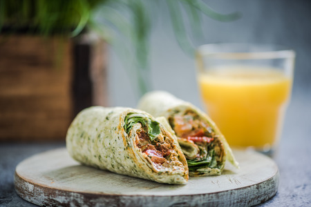 serving healthy breakfast, wrap and orange juiceの写真素材