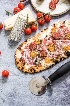 Traditional stone ovew baked pizza with ingredients on slate backgroundの写真素材