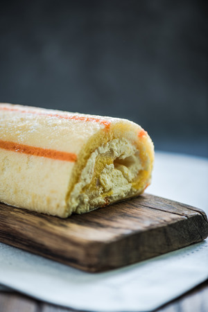 swiss roll with creme on wooden boardの写真素材